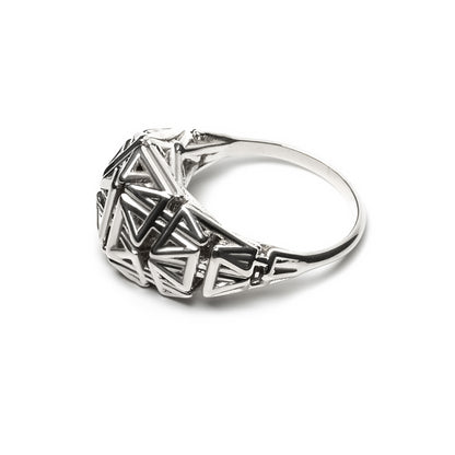 Side view of a sterling silver ring with a crown of angular latticework springing from a narrow band.
