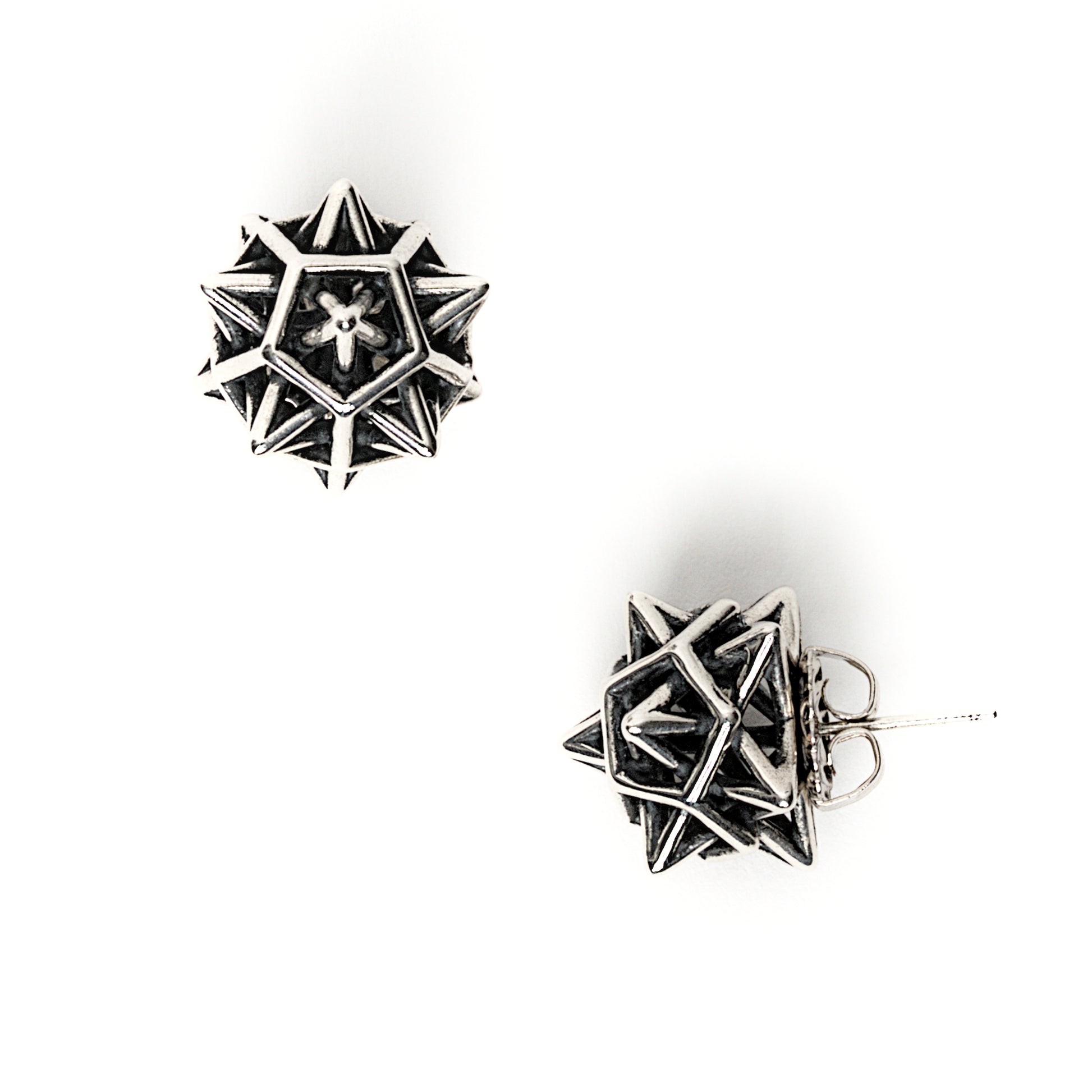 The contrast oxidized version of our solid sterling "Morningstar" earrings is shown here. Blackening the recessed areas of the design help the interlocking geometries pop. Each protruding spike is polished to a mirror finish. The star shapes seen at certain angles of the design are emphasized. 