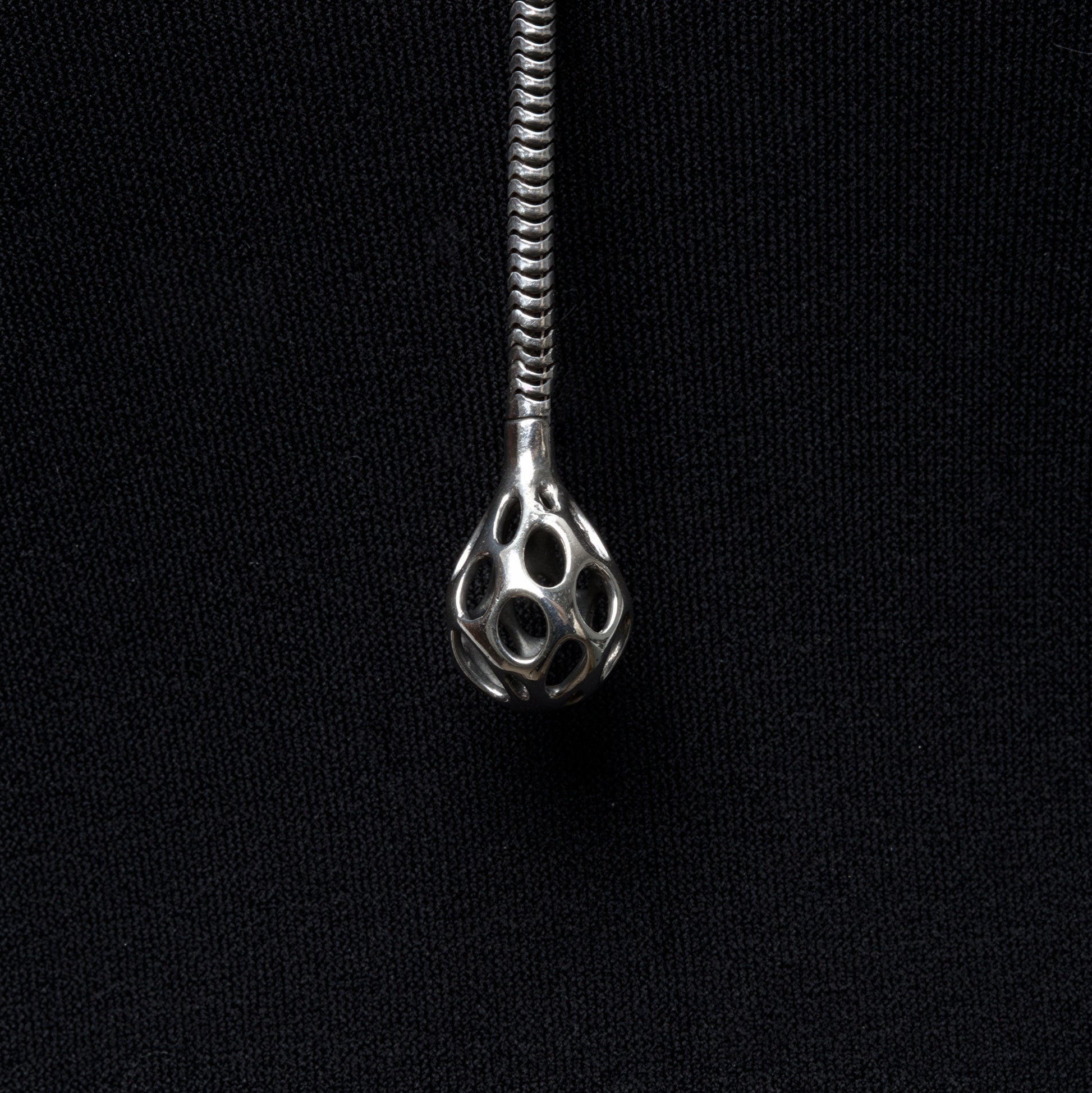 Close up detail of the sterling silver sculptural droplet emerging from the thick snake chain lariat necklace. 