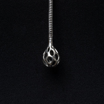Close up detail of the sterling silver sculptural droplet emerging from the thick snake chain lariat necklace. 