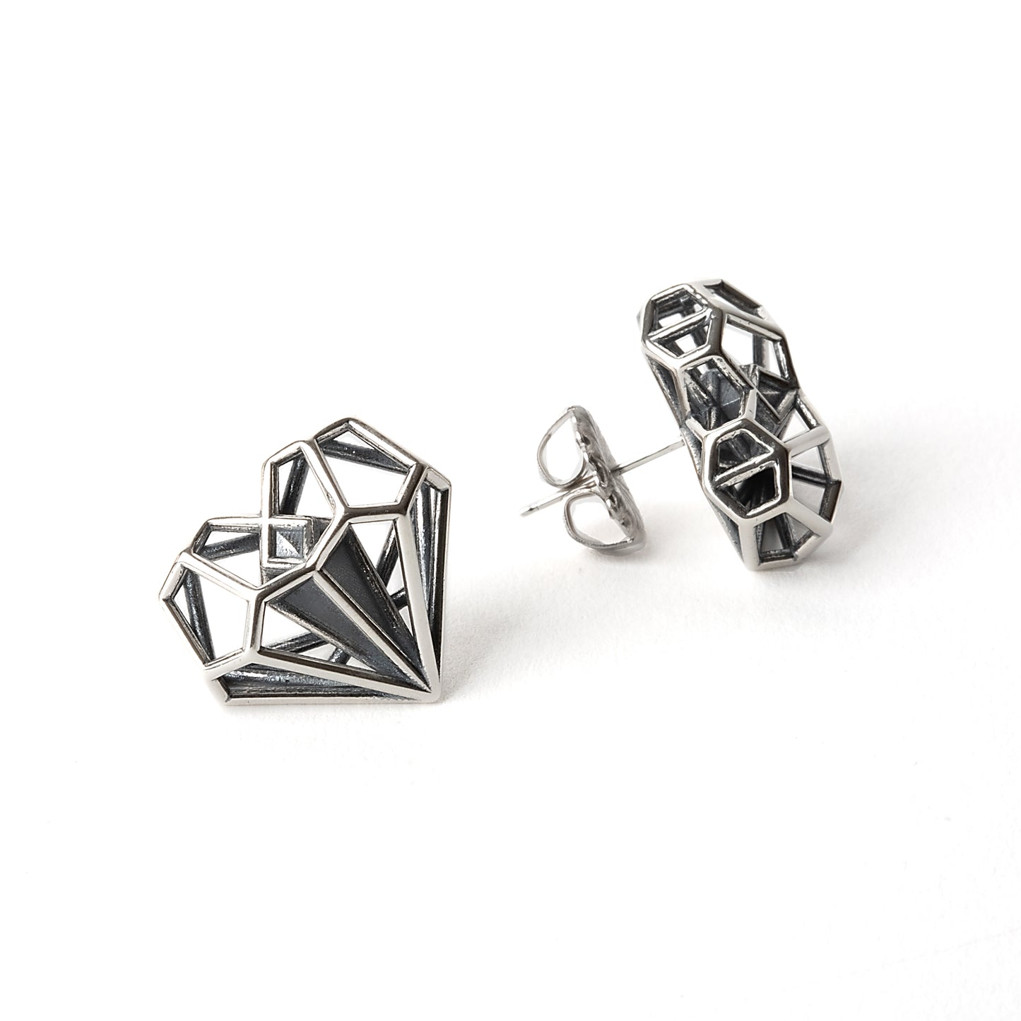 Sterling silver geometric heart shaped earrings backed with hand soldered notched posts for pierced ears. These latticework studs were designed by Xover0 Jewelry to match their iconic necklace that was used as a plot device in the Netflix movie Uglies.