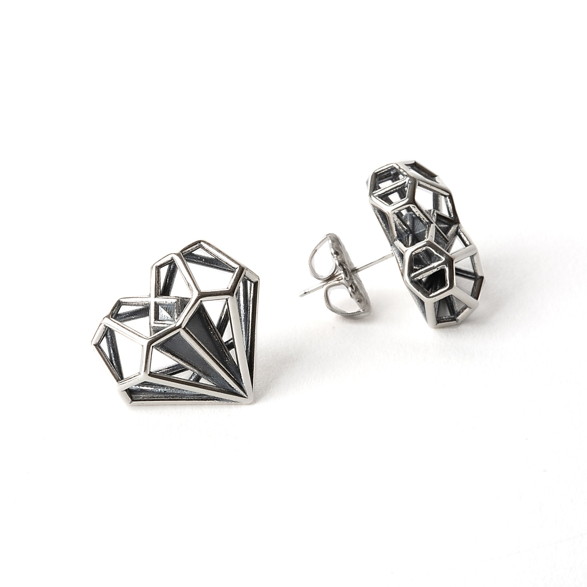 Sterling silver geometric heart shaped earrings backed with hand soldered notched posts for pierced ears. These latticework studs were designed by Xover0 Jewelry to match their iconic necklace that was used as a plot device in the Netflix movie Uglies.