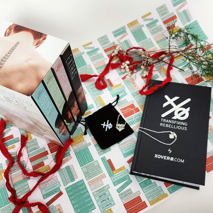 Xover0 custom Book Safe displayed alongside the Uglies 4-book series box set, with the Geoheart Pendant necklace resting on top of its black velvet pouch.