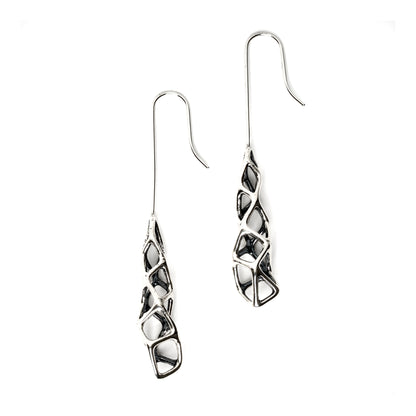 Edgy elongated drop earrings in solid sterling silver featuring dimensional geometric lattices with extreme contrast between blackened recesses and high polish outer surfaces. The dimensional design emphasizes vertical length, gravity, and unconventional elegance. 