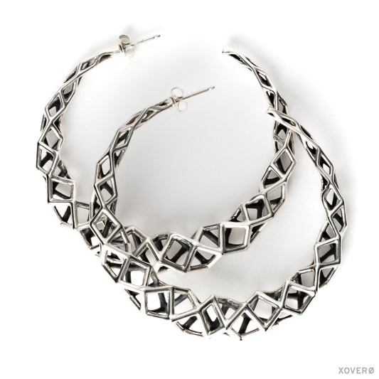 A pair of geometric lattice hoop earrings in solid sterling silver. These sculptural earrings are contrast oxidized for added impact. They are backed with matching .925 hand soldered posts. 