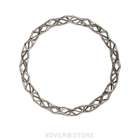 A sterling silver bangle bracelet with a highly polished dimensional lattice geometry. The delicate form is packed with light scattering detail. 