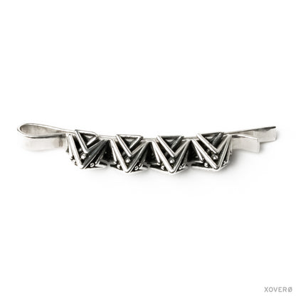 Three quarter view of a sterling silver handmade bobby pin crowned in spikes showing its solid construction and detailed architectural precision.
