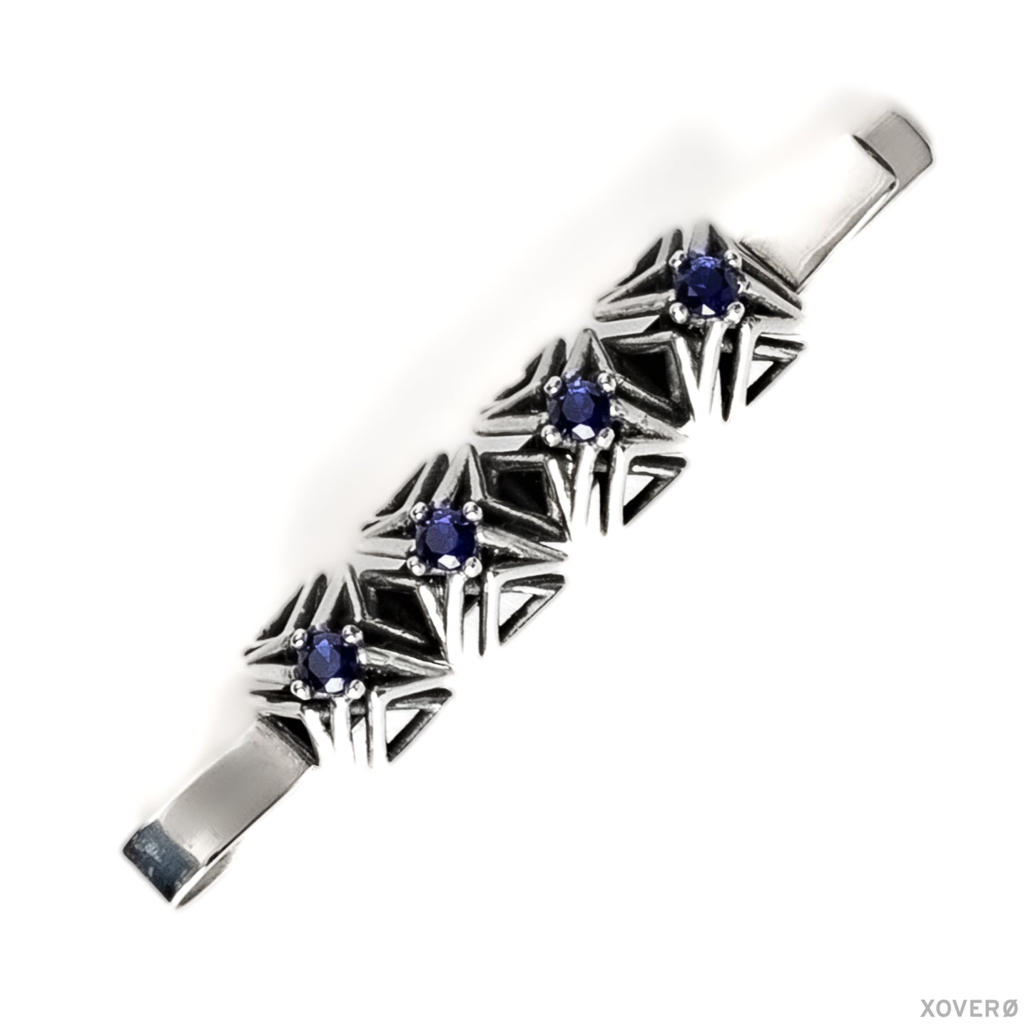 An heirloom sterling silver bobby pin with four hand-set sapphires in a geometric latticework of pointed spikes.