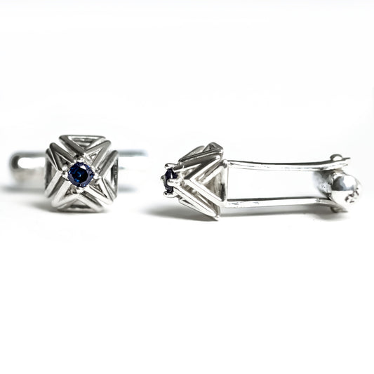Blue sapphire and solid sterling silver cuff-links with toggle backs on a white background. 