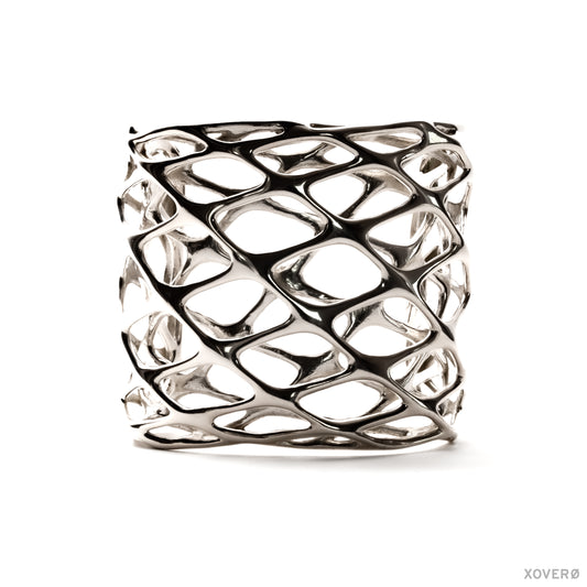 A tall, chunky sterling silver cuff bracelet with a layered geometric lattice pattern. The statement accessory has an angular edgy aesthetic. 