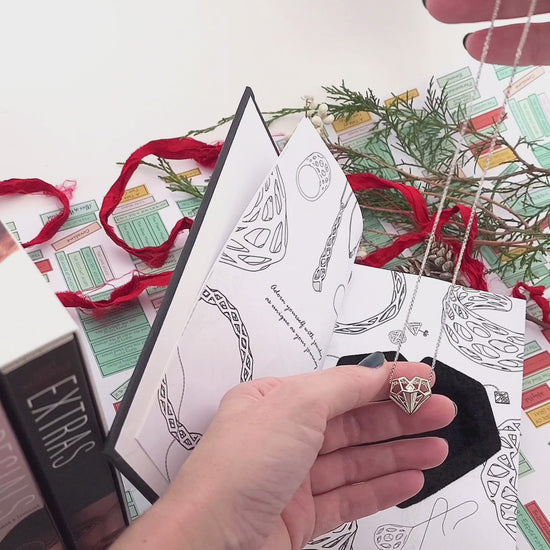 Xover0 custom Book Safe packaging, an exclusive upgrade with the Geoheart Pendant, perfectly sized to stack on top of an Uglies book for discreet gift wrapping. When wrapped together, the recipient will expect books but be pleasantly surprised to find a hidden keepsake necklace inside.