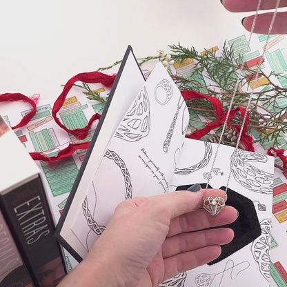 Xover0 custom Book Safe packaging, an exclusive upgrade with the Geoheart Pendant, perfectly sized to stack on top of an Uglies book for discreet gift wrapping. When wrapped together, the recipient will expect books but be pleasantly surprised to find a hidden keepsake necklace inside.