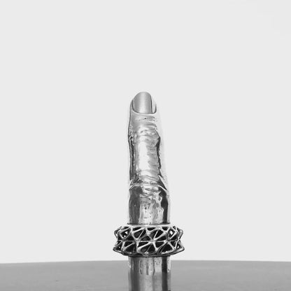 The Aṅgulimāla sterling silver pendant shaped like a human finger is shown from all angles on a turn table. 