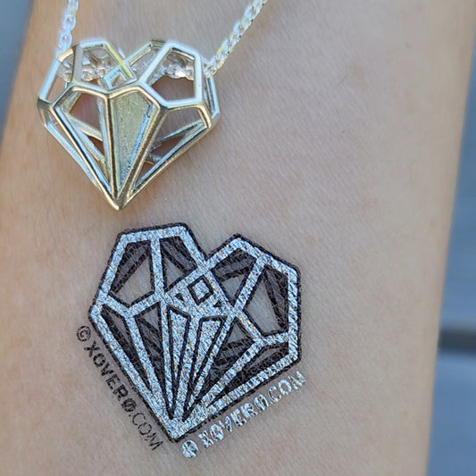 High quality metallic silver temporary tattoos of Tally's Heart Pendant from Netflix's Uglies movie. This design stands out equally well on all skin tones. Seen here on pale skin. 