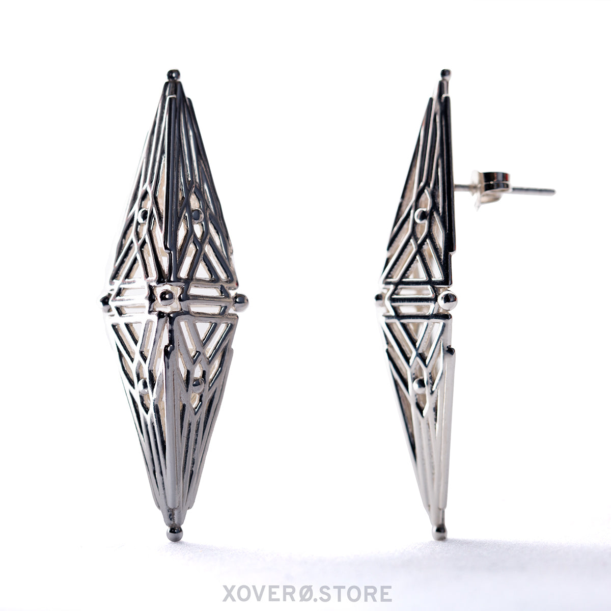 A pair of sterling silver diamond-shaped earrings with branching articulations and a notched post.