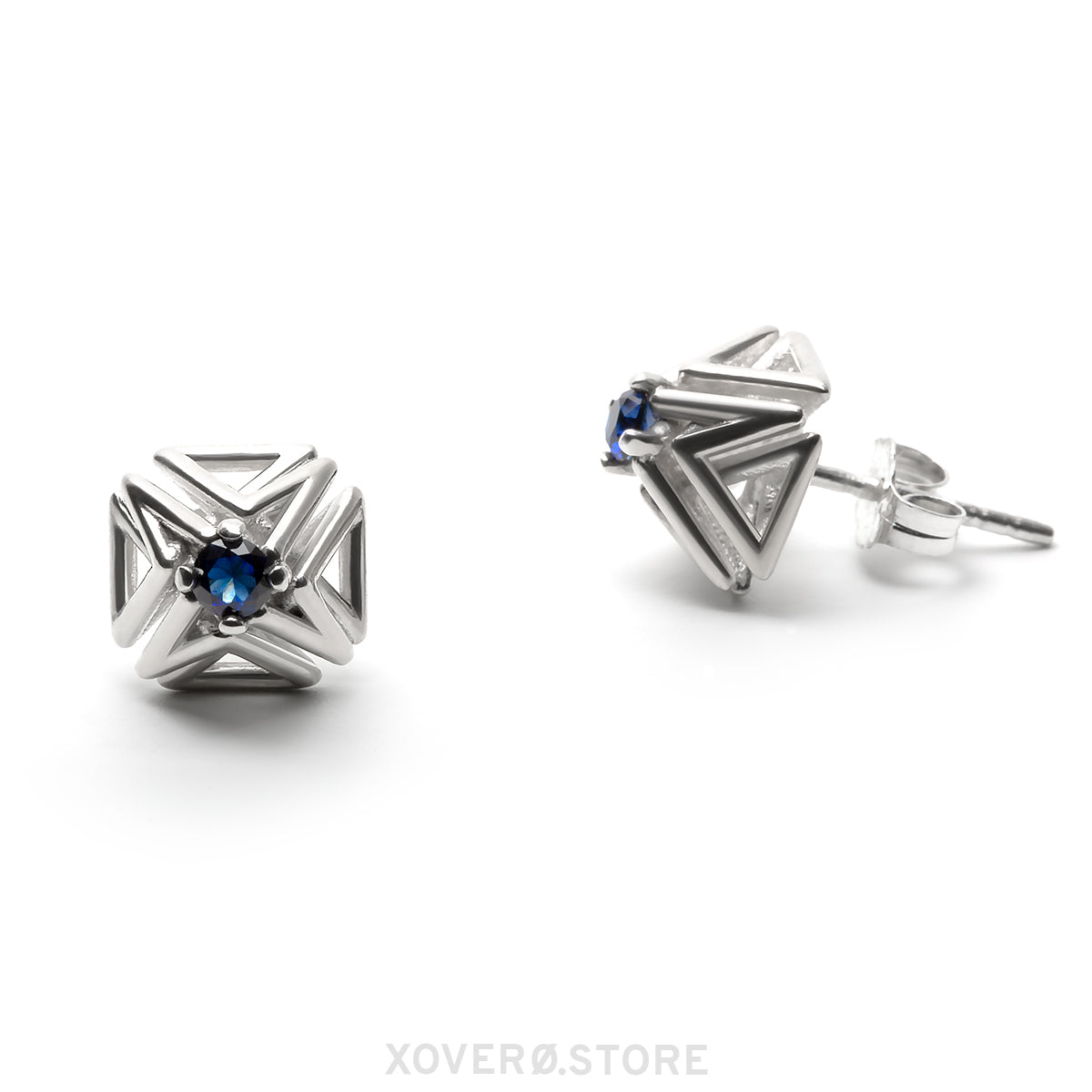 Sterling silver spike stud earrings with dimensional latticework set with faceted sapphires. One earring is shown from the front, the other from a side view showing the hand-soldered notched post and ear nut. 