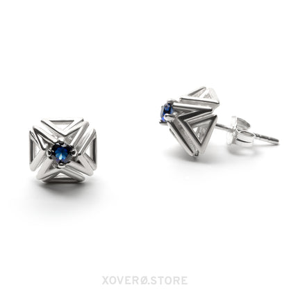 Sterling silver spike stud earrings with dimensional latticework set with faceted sapphires. One earring is shown from the front, the other from a side view showing the hand-soldered notched post and ear nut. 
