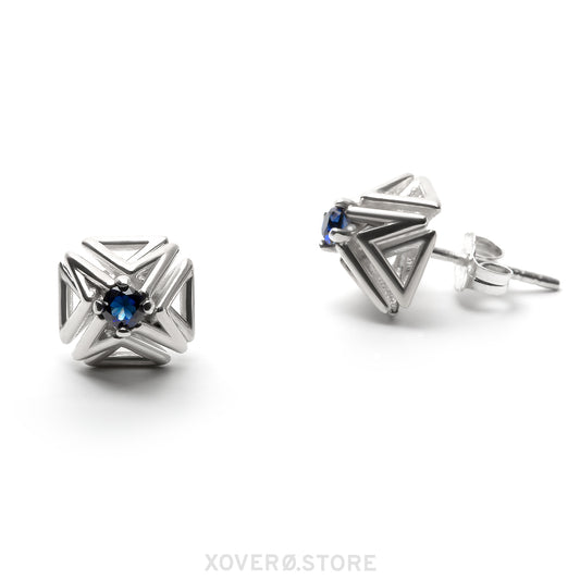 Sterling silver spike stud earrings with dimensional latticework set with faceted sapphires. One earring is shown from the front, the other from a side view showing the hand-soldered notched post and ear nut. 