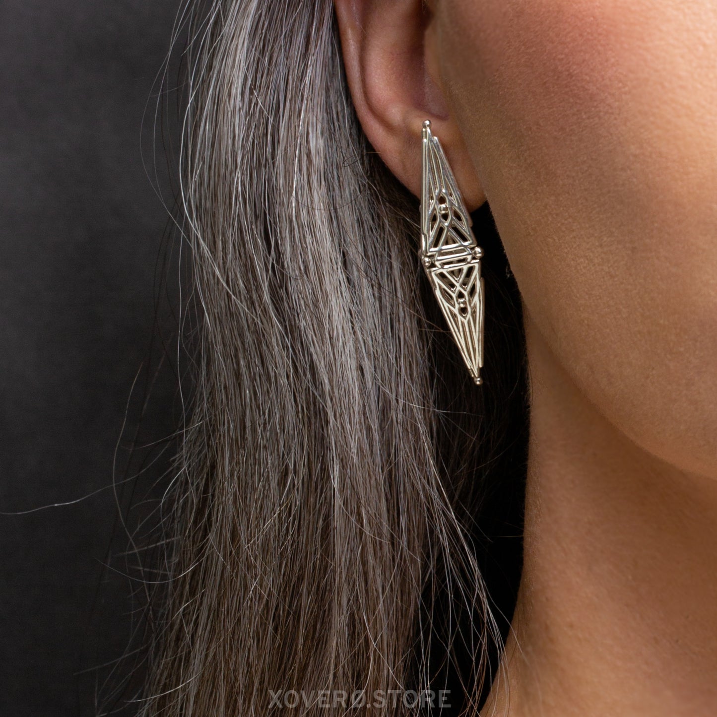 Close-up of one solid .925 sterling silver earring worn, showcasing angular geometric lattices inspired by Art Deco design from 1925 to 1939.